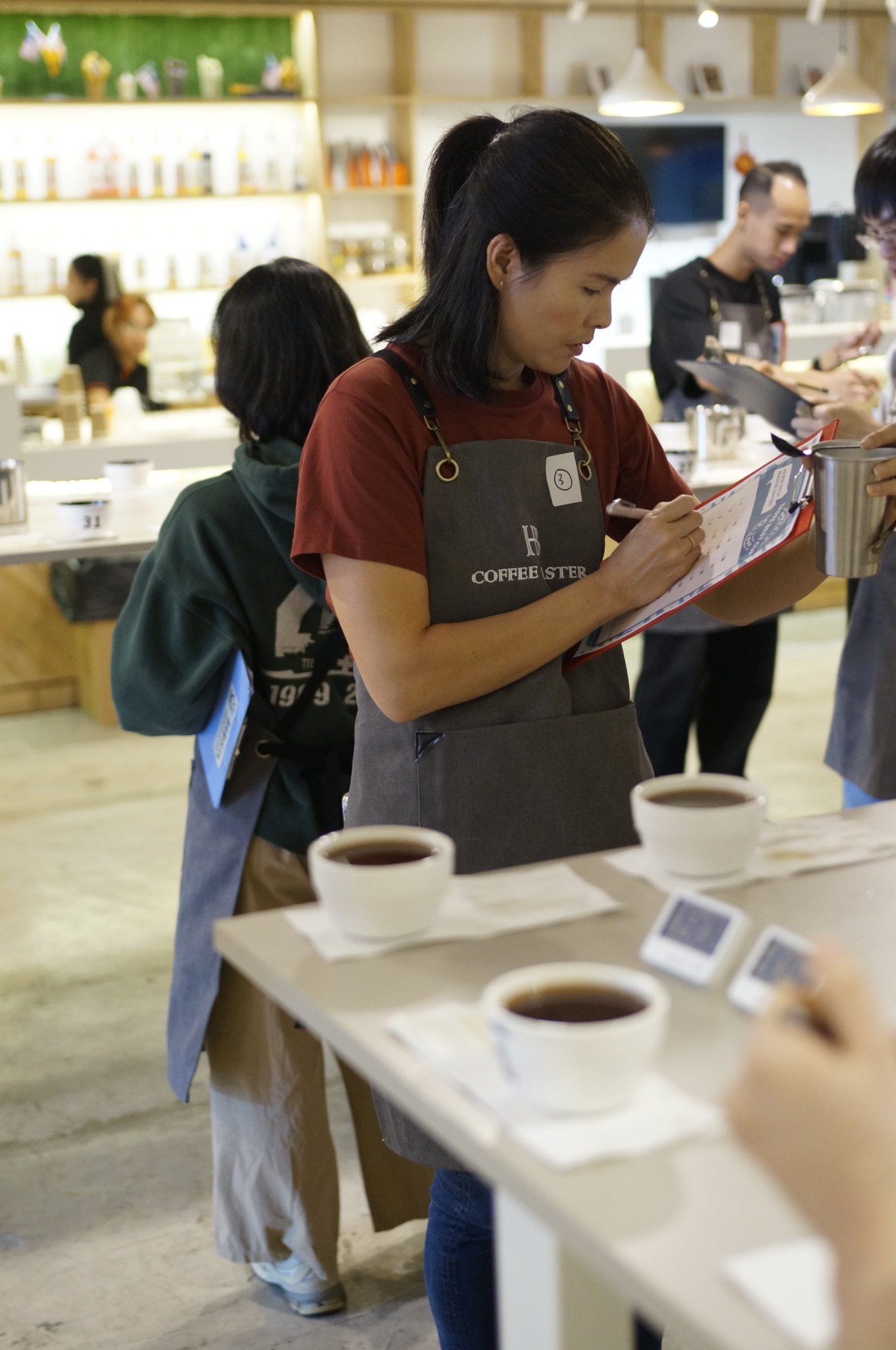 เจ้าของ Behind the Bar ทำหน้าที่กรรมการประเมินกาแฟและบันทึกคะแนนในงานแข่งขัน